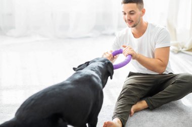 adam köpeğiyle ev oynarken oturma