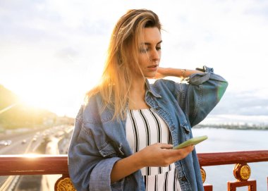 gün batımında kız serbest meslek telefon ve eserler üzerinde konuşuyor