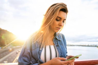 gün batımında kız serbest meslek telefon ve eserler üzerinde konuşuyor