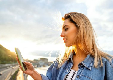 Kız serbest meslek günbatımında telefon ile çalışma