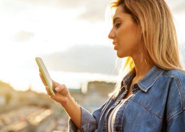 Kız serbest meslek günbatımında telefon ile çalışma