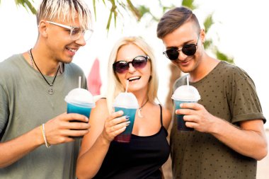 üç arkadaş neşeli şirket kalan bir tropikal plaj ve içki kokteylleri, çok, dergi kavramı