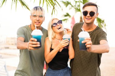 üç arkadaş neşeli şirket kalan bir tropikal plaj ve içki kokteylleri, çok, dergi kavramı