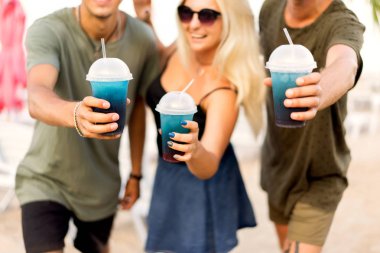 üç arkadaş neşeli şirket kalan bir tropikal plaj ve içki kokteylleri, çok, dergi kavramı