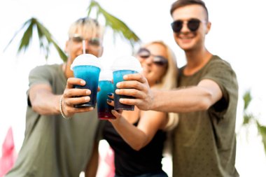 üç arkadaş neşeli şirket kalan bir tropikal plaj ve içki kokteylleri, çok, dergi kavramı