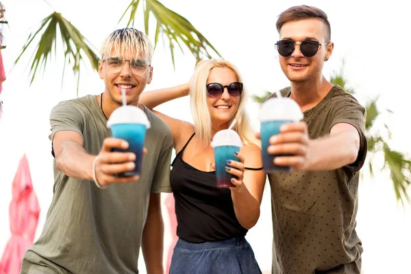 三朋友愉快的公司休息在热带海滩和喝鸡尾酒 杂志概念 — 图库照片