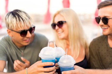 üç arkadaş sahilde kokteyl eğlenceli içme