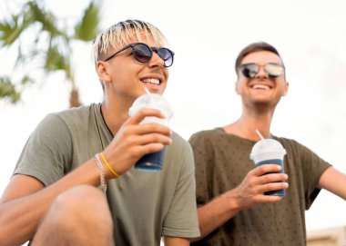 iki adam bir tropik sahilde kokteyl içmek