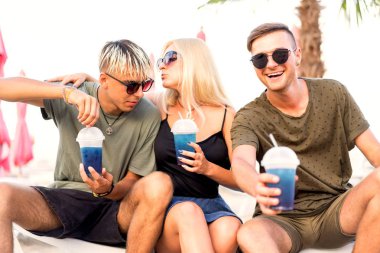 üç arkadaş sahilde kokteyl eğlenceli içme