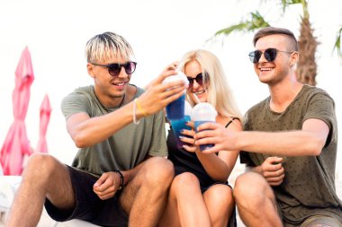 üç arkadaş sahilde kokteyl eğlenceli içme