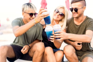 üç arkadaş sahilde kokteyl eğlenceli içme