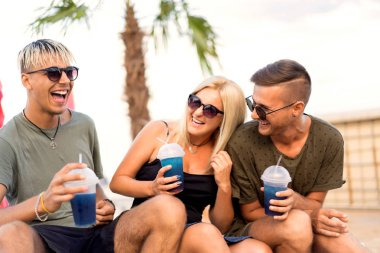 üç arkadaş sahilde kokteyl eğlenceli içme