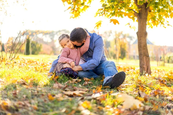 秋の公園を散歩して夕日の娘と幸せなお父さん — ストック写真