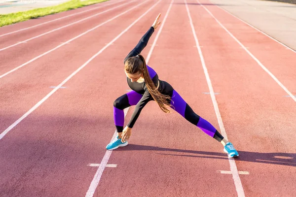 Dziewczyna Sportowca Krzyś Kuca Przeciw Zachodzie Słońca Stadionie — Zdjęcie stockowe