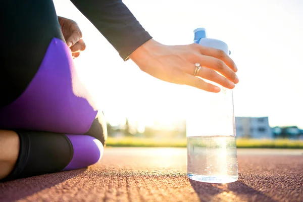 女孩运动员交叉适合和蹲在和喝水在日落 — 图库照片
