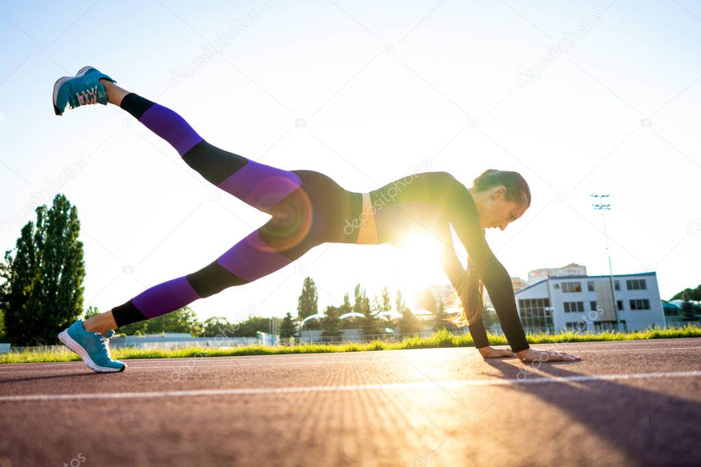 girl sportsman crossfit and run at sunset in the stadium