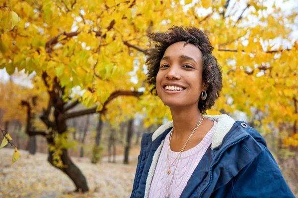 Afroamerican girl listening to music in the autumn at sunset — Stock Photo, Image