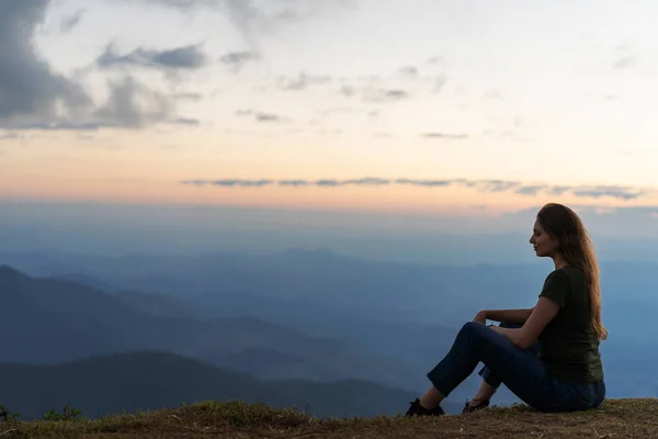坐在日落时的女孩坐在山上 — 图库照片