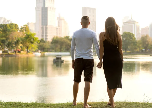 Paar in de liefde lachen kijken naar elkaar in het Bangkok Park en tropische drieën — Stockfoto