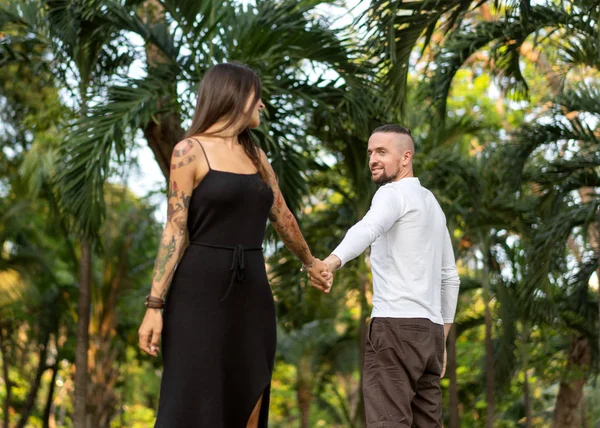 Pareja enamorada riéndose mirándose en el parque de Bangkok y tríos tropicales — Foto de Stock