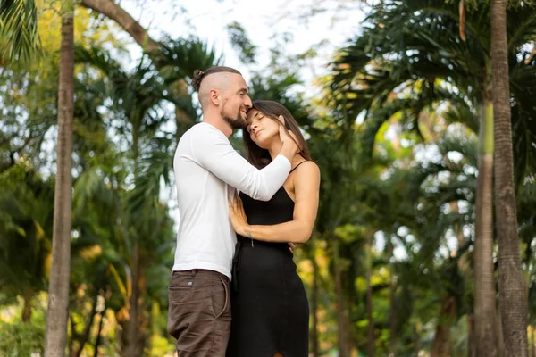 Pareja enamorada riéndose mirándose en el parque de Bangkok y tríos tropicales — Foto de Stock