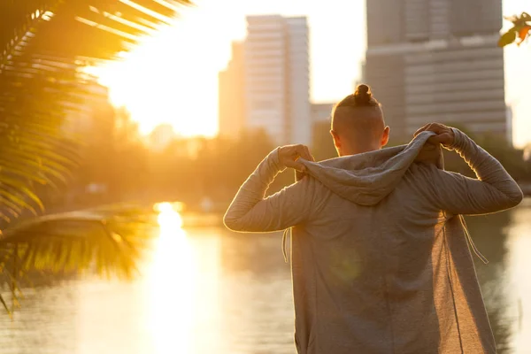 Cara de moda de pé ao pôr do sol em palmeiras tropicais — Fotografia de Stock