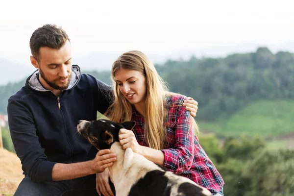 Pareja enamorada de un perro en las montañas —  Fotos de Stock