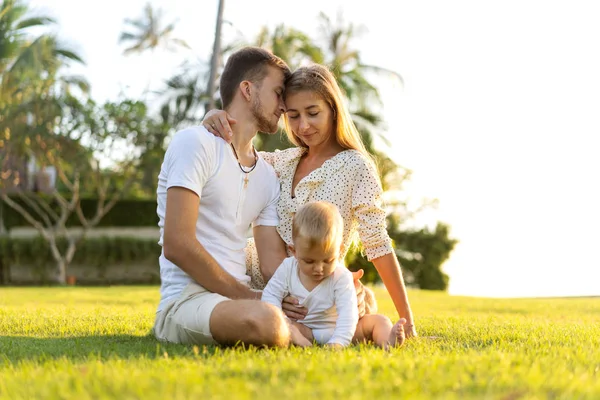 Happy family on tropical island at sunset playing with son — Stock Photo, Image