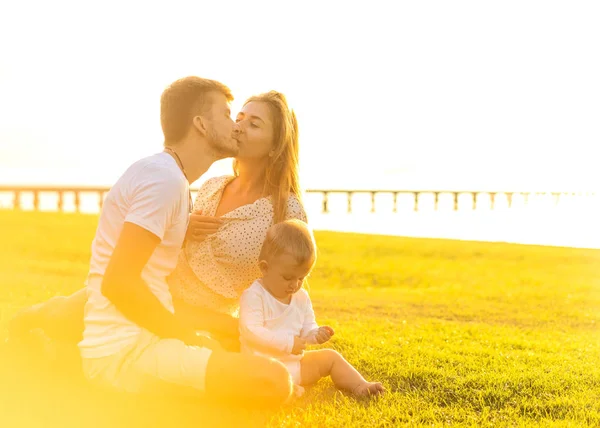 Lycklig familj på tropiska ö vid solnedgången leker med son — Stockfoto