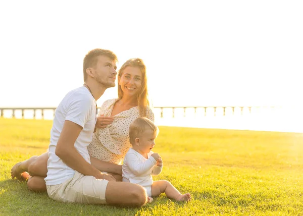 Lycklig familj på tropiska ö vid solnedgången leker med son — Stockfoto