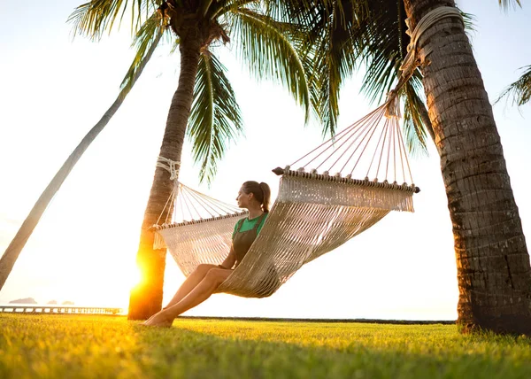 在吊床的女孩打扰棕榈树享受热带度假 — 图库照片
