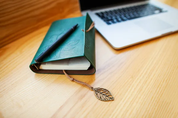 Notebook is op de tafel in de buurt van de computer — Stockfoto