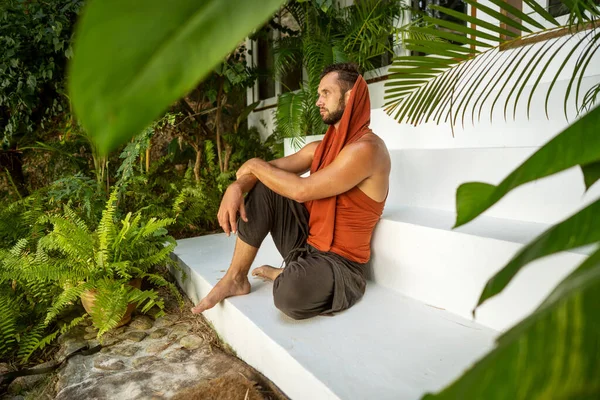 ファッション男は熱帯ヤシの木に座って — ストック写真