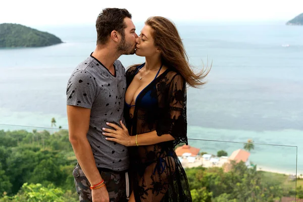 Pareja enamorada están de pie al atardecer con vistas al mar — Foto de Stock