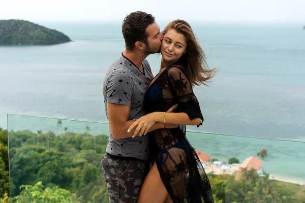 Pareja enamorada están de pie al atardecer con vistas al mar — Foto de Stock