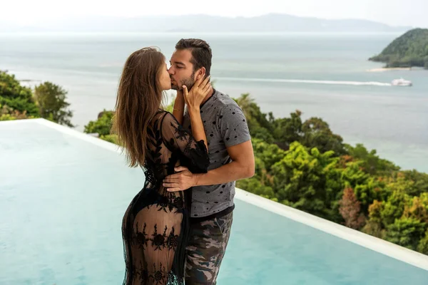 Pareja enamorada están de pie al atardecer con vistas al mar — Foto de Stock