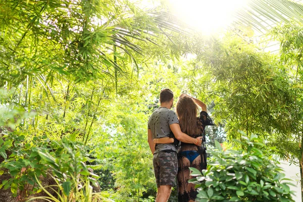 Couple amoureux sont debout au coucher du soleil dans la jungle — Photo