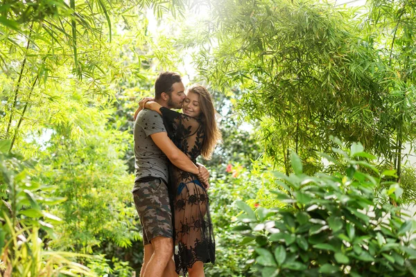 Paar in de liefde staan bij zonsondergang in de jungle — Stockfoto