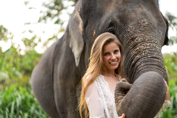 Mädchen umarmt einen Elefanten im Dschungel — Stockfoto