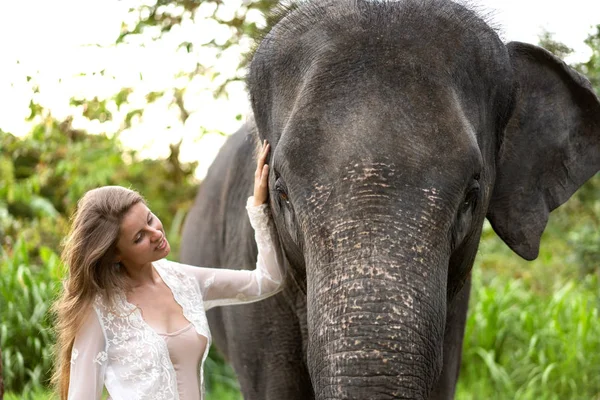 Fille étreignant un éléphant dans la jungle — Photo