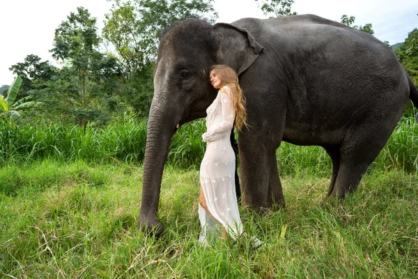 Fille étreignant un éléphant dans la jungle — Photo