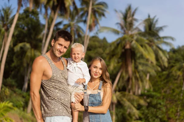 Rodina chodí po pláži při západu slunce se svým synem: pohled zpět na siluetu — Stock fotografie