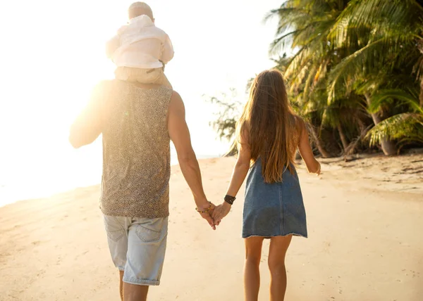 Paseo familiar por la playa al atardecer con su hijo: silueta de vista trasera — Foto de Stock