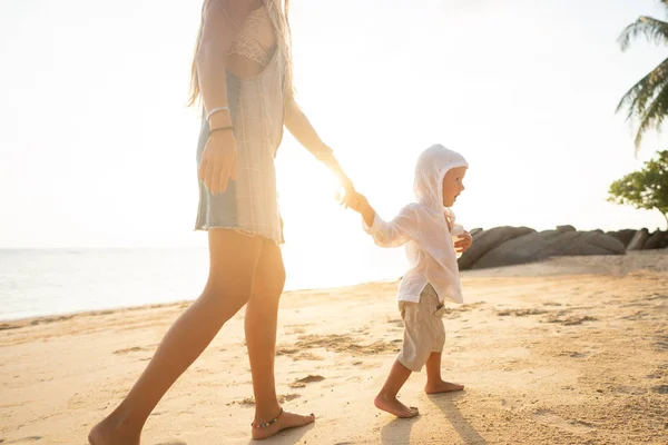 Anne gün batımında oğluyla tropik bir plajda oynuyor. — Stok fotoğraf