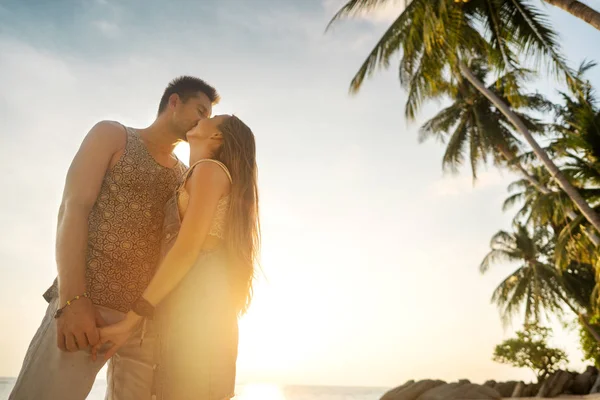 Birbirlerine aşık çiftler gün batımında sahilde — Stok fotoğraf