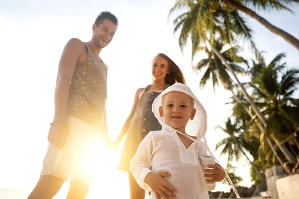 Família apaixonada na praia com o filho estão brincando ao sol — Fotografia de Stock