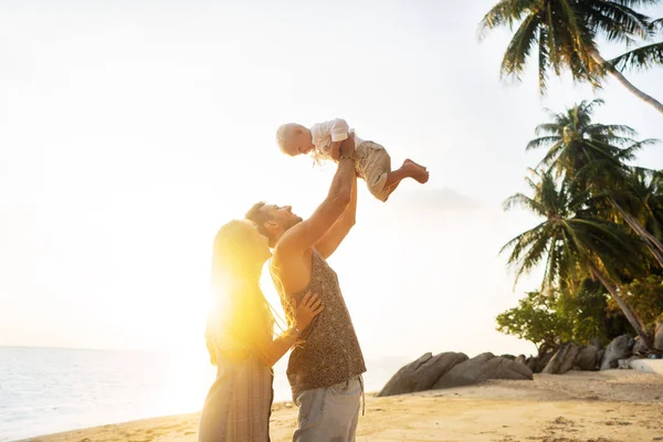 Familia enamorada en la playa con hijo están jugando al sol —  Fotos de Stock