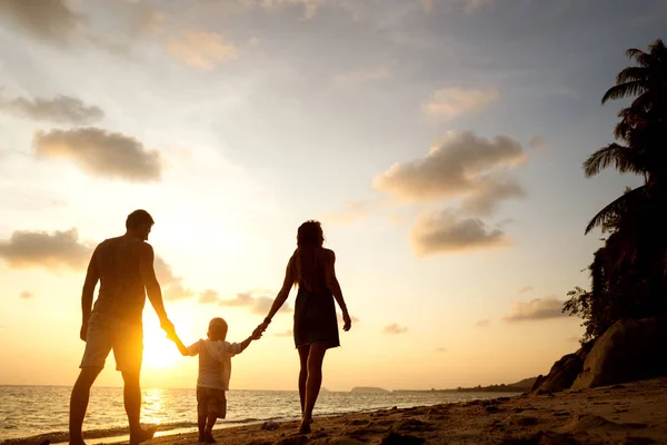 Familienspaziergang am Strand bei Sonnenuntergang mit seinem Sohn: Silhouette von hinten — Stockfoto