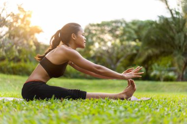 parkta Tayland'da gün batımında yoga yapan kız