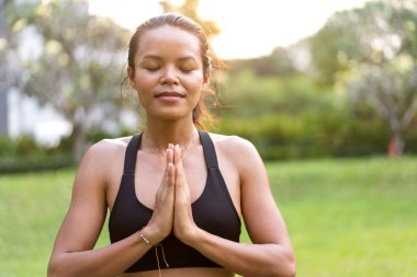 parkta Tayland'da gün batımında yoga yapan kız